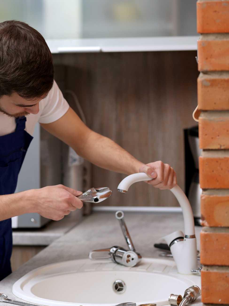 plumber installing kitchen faucet
